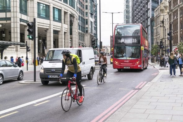 Cyclists and Modern Red London Bus
